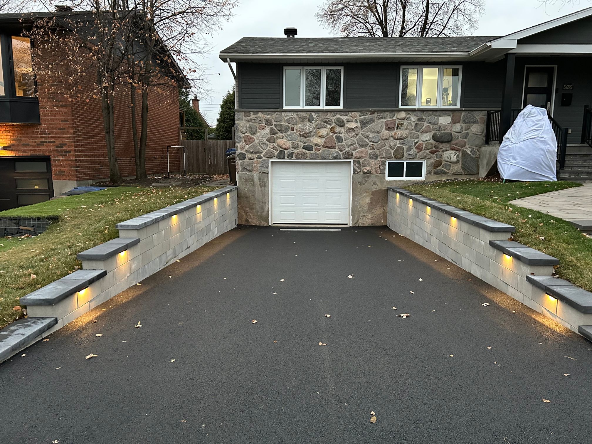 Entrée de cour en asphalte avec muret en brique à Brossard, après les travaux effectués par Paysagement et excavation Campex.